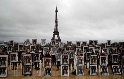 Экоактивисты устроили в Париже акцию протеста с перевернутыми портретами Макрона